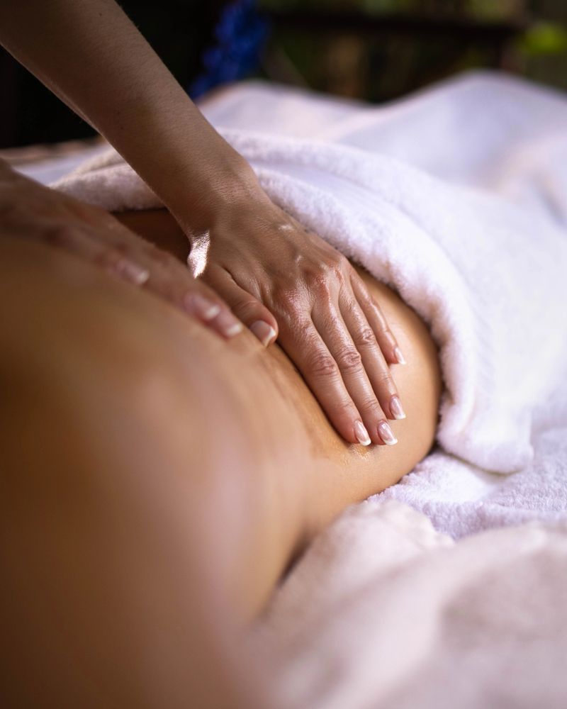 Close up of unrecognizable therapist giving a woman back massage at the spa.