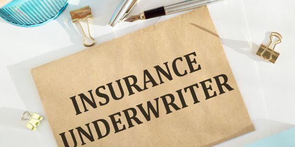 Sign reading 'Insurance Underwriter' on brown paper.