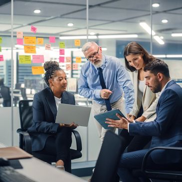 four people at work collaborating and sharing ideas as a team