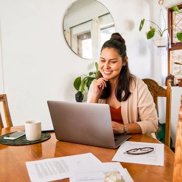 Woman smiling while working on laptop.