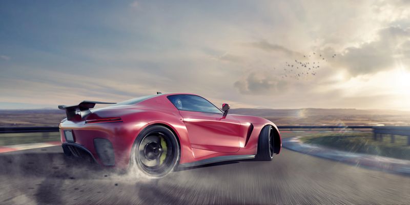 A generic red sports car moving at high speed around the corner of a racetrack. The vehicle is drifting around the corner, with smoke coming from its spinning rear tires. The racetrack is fictional in a remote location with distant hills. It is sunset/sunrise under a cloudy sky.