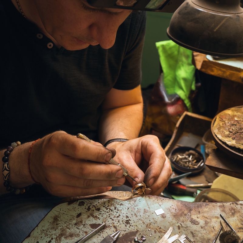 An employee of a jewelry workshop repairing a gold ring