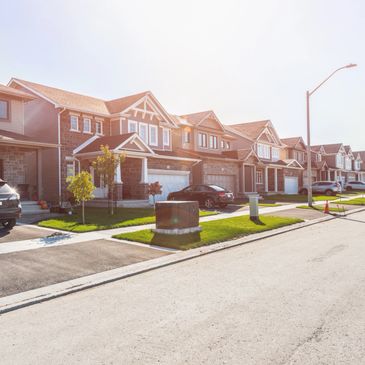 Row of suburban houses lined up on a sunny day.