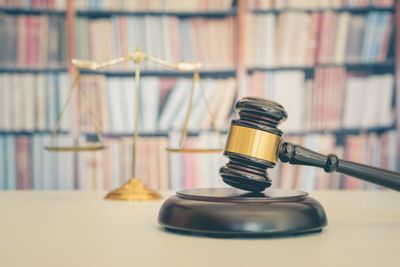 Judge's gavel and balance scale on desk.