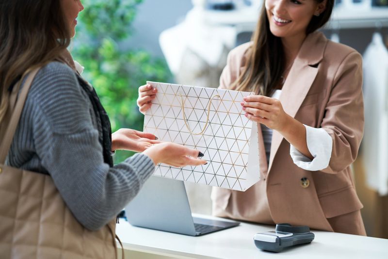 Cashier and buyer in cloth store during transaction. High quality photo