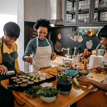Friends cooking and enjoying a meal together in a cozy kitchen.