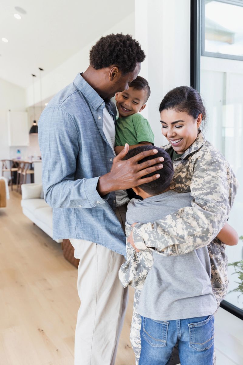 Standing in the front entry of their home, the family is happy to be reunited with the soldier mom.