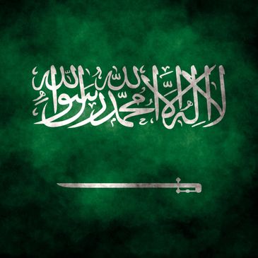 The flag of Saudi Arabia with white Arabic script and a sword on a green background.