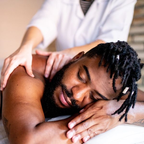 Man enjoying a relaxing massage with eyes closed and calm expression.