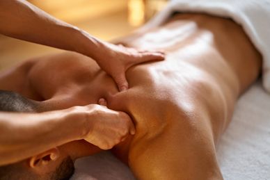 Person receiving a deep tissue back massage with focused hand pressure.