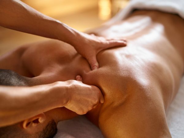 Person receiving a deep tissue back massage in a relaxing setting.
