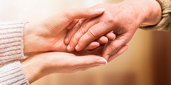 Two people holding hands in a comforting gesture.