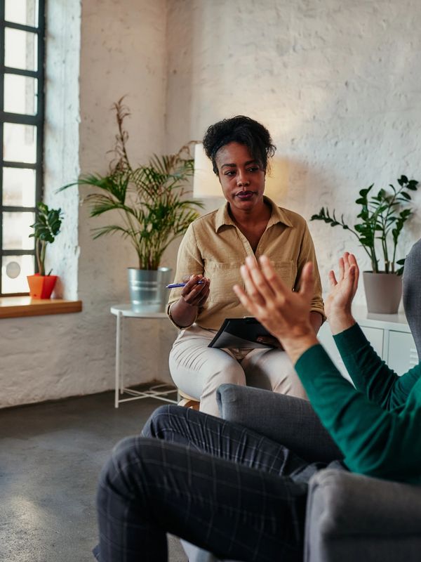 A man talks emotionally during a therapy session with a woman.