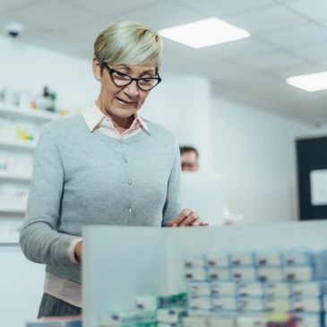 Mature woman selecting medicine in a pharmacy.