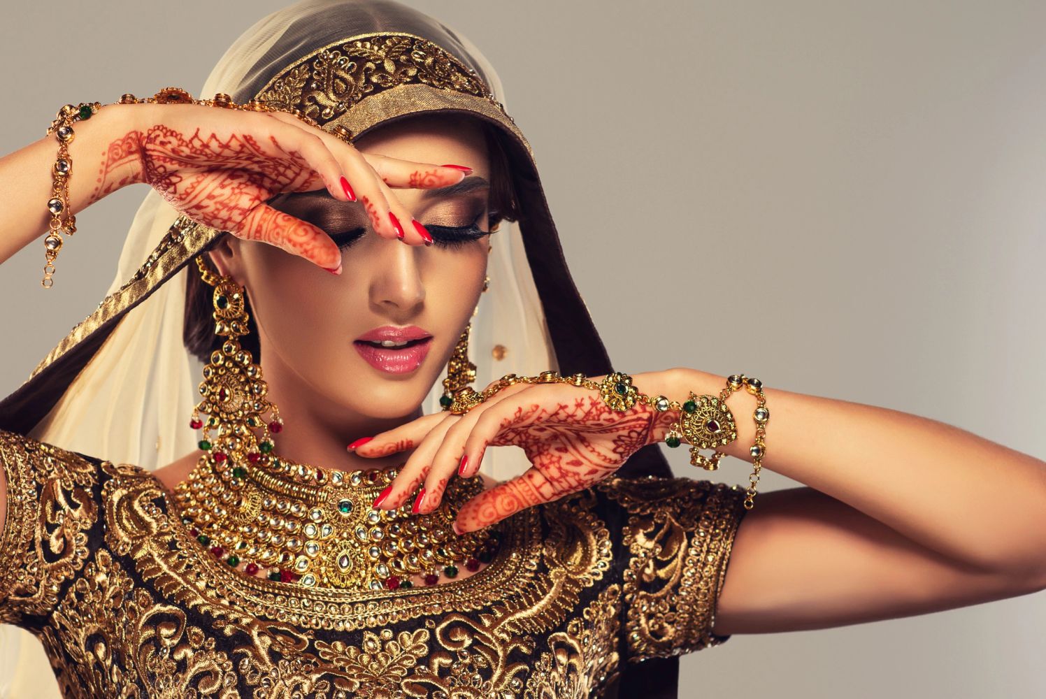 Young Indian woman in bridal choli with henna and gold jewelry