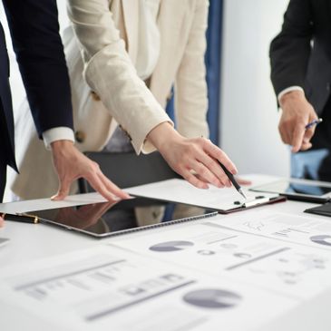 Business team analyzing financial charts and documents on a table.