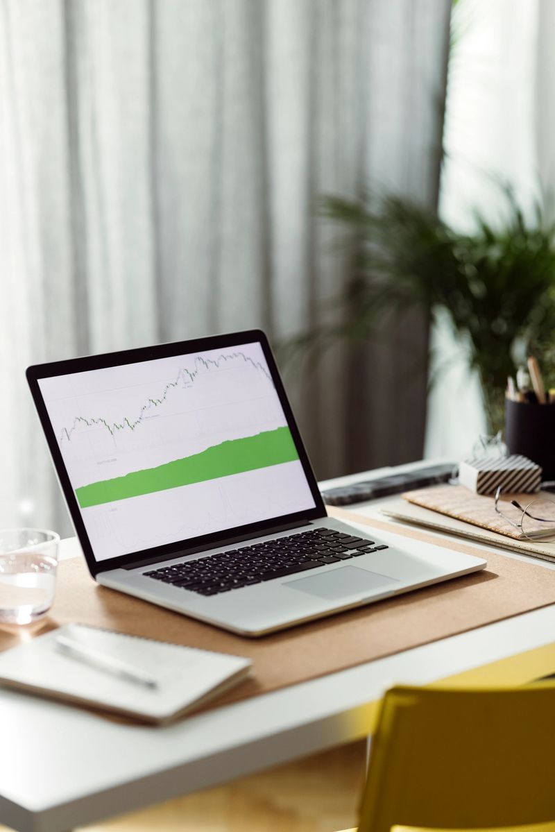 Laptop computer screen with a increasing graph on a home office desk.