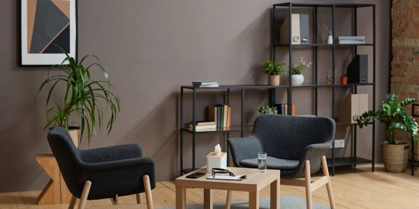 Cozy modern sitting area with two armchairs and a wooden table.