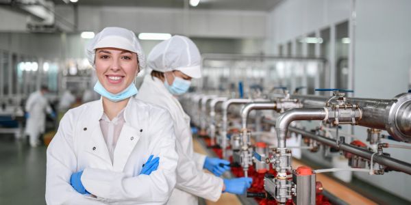 Smiling female factory worker in protective clothing.