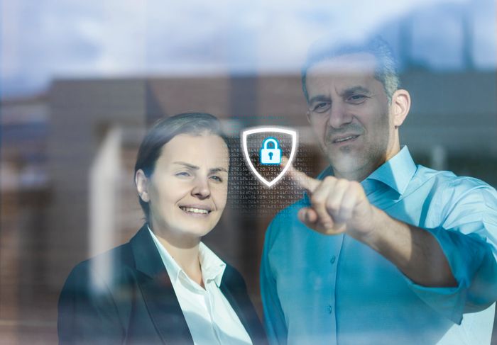 Three coworkers collaborating late at night with code on their screens.