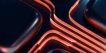 Close-up of sleek black surfaces with glowing red lines forming a futuristic pattern. Sustainable growth and operational excellence.
