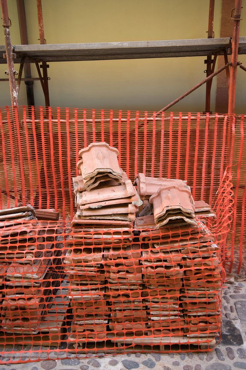 stack of tiles, scaffolding along the sidewalk for the renovation of an old building in the city center