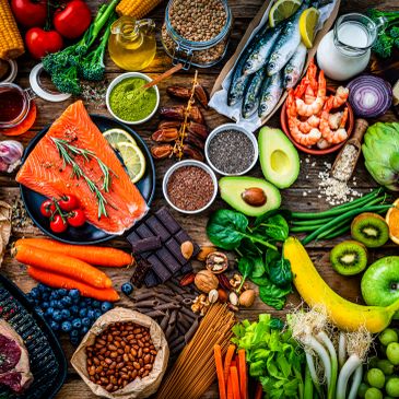 A colorful assortment of healthy foods including fruits, vegetables, nuts, fish, and grains.