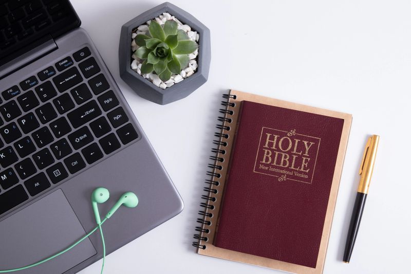 Bible and laptop on the work table with headphones. Bible Study Online concept