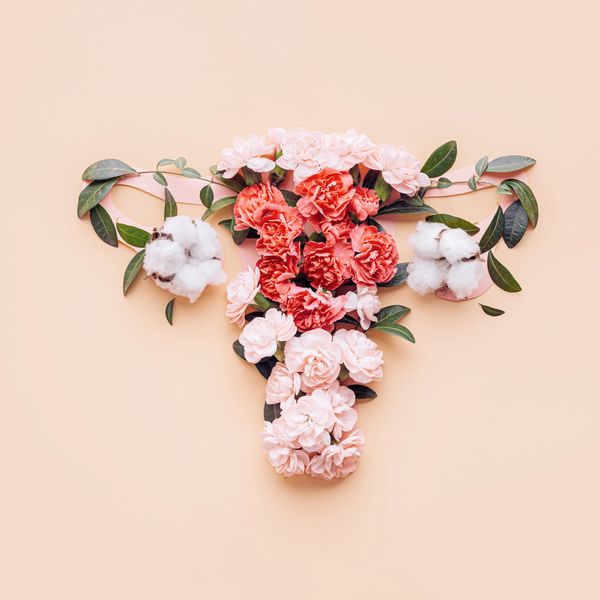 Floral arrangement shaped like a uterus with pink and red flowers.