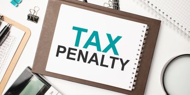 Notebook with 'TAX PENALTY' text surrounded by office supplies.