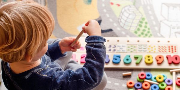 Child playing with colorful educational toy numbers.