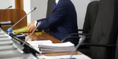 Person in a blue suit sitting at a conference table.