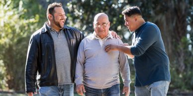 Three men enjoy a walk in a park.