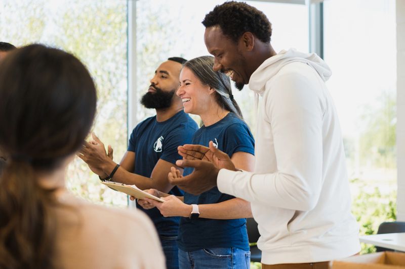 The diverse group of volunteers smile and laugh together.