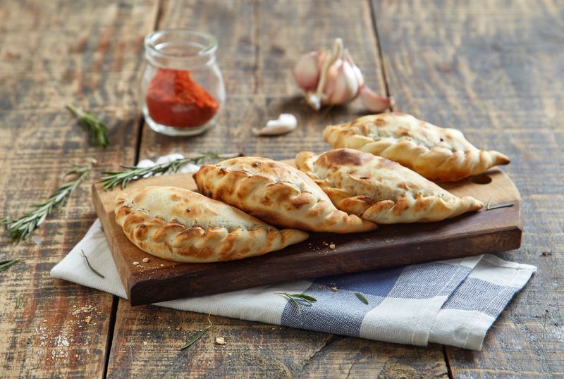 Rustic wooden table with spicy empanadas board