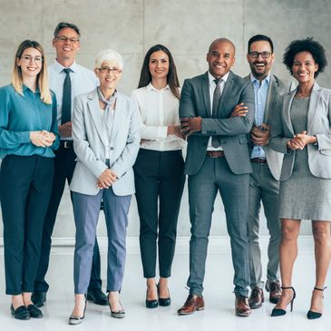 Diverse group of professionals standing confidently in formal attire.