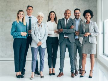 Group of diverse business professionals standing and smiling.