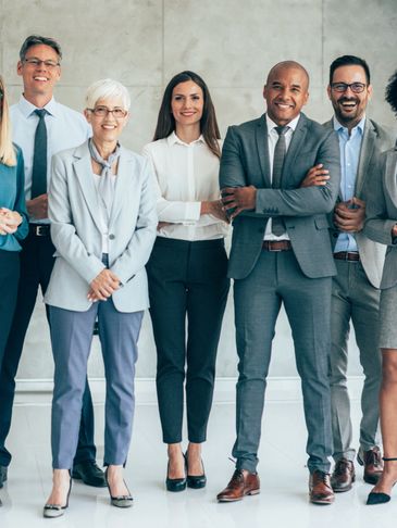 A diverse group of confident professionals standing together in a modern office.