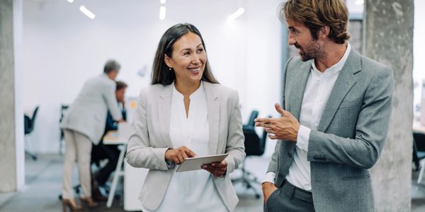 Two colleagues engaging in a friendly conversation in an office.