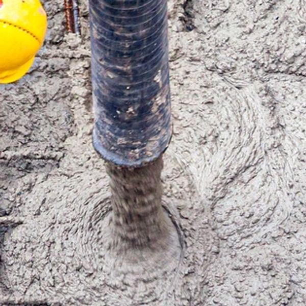 Concrete being poured from a pipe.