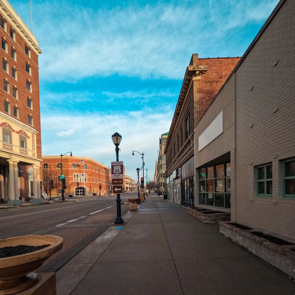 A quiet street in a historic downtown area under a blue sky.