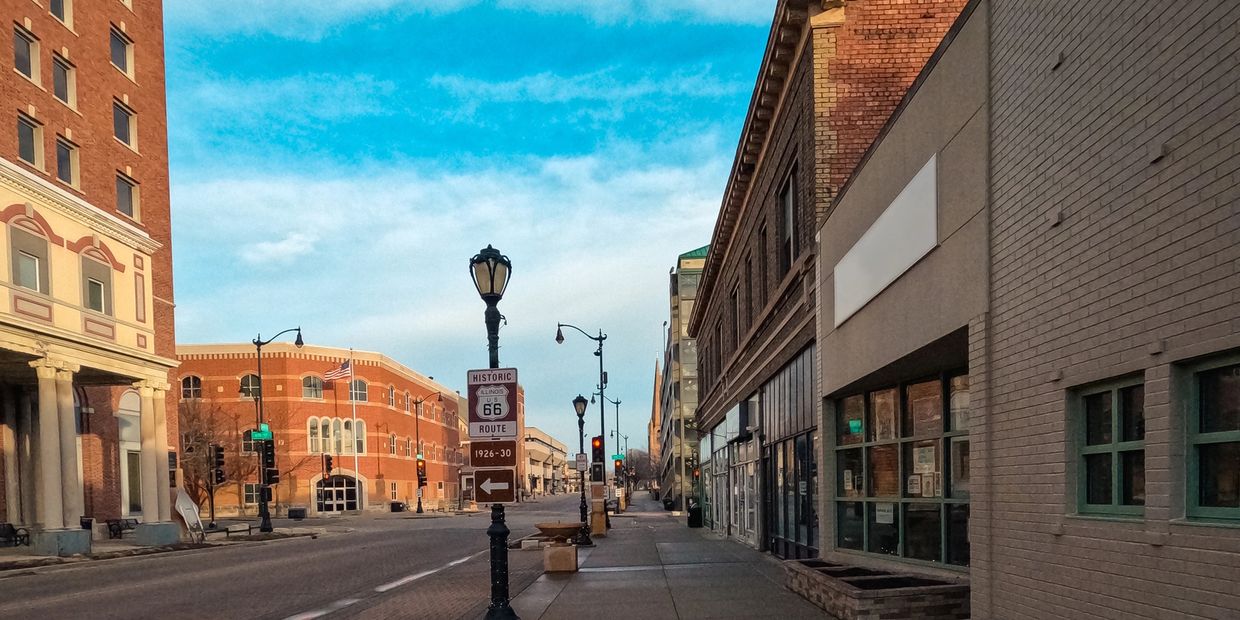 A quiet street in a historic downtown area under a blue sky.