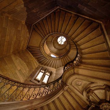 Spiral staircase with intricate railings and warm lighting.