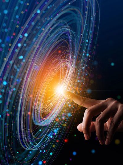 Finger touching a glowing vortex of light and particles.