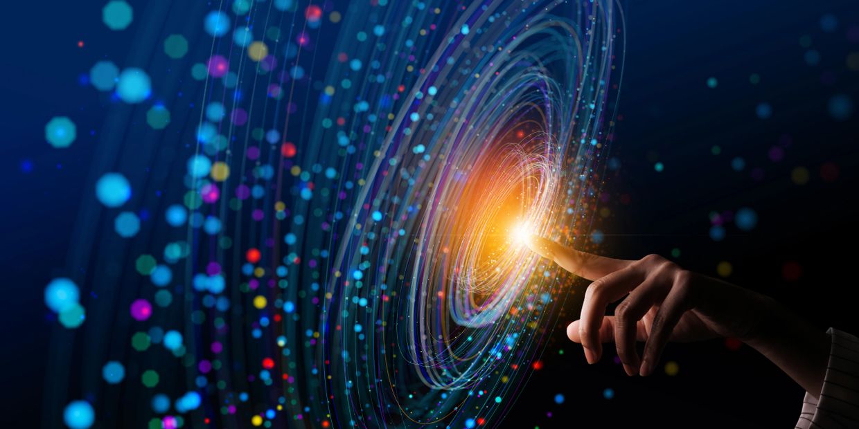Hand touching a glowing digital vortex with colorful particles.