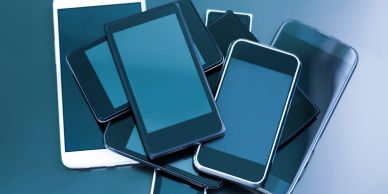 A pile of various modern smartphones stacked together.