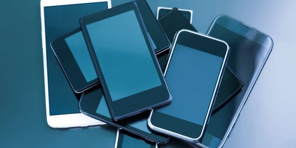 Pile of modern smartphones and tablets.