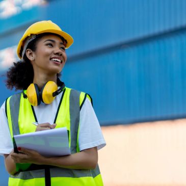 Female construction worker with helmet and clipboard.