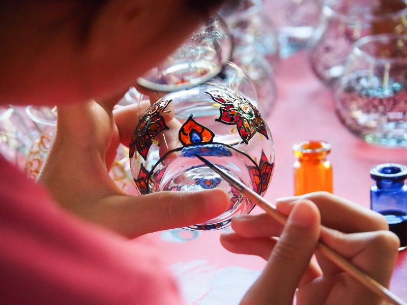 Close up Girl hands using brush painting on glass. Concept craft activities for kids, fun practice for kids, how to do stained glass, handcraft art, finger exercise.