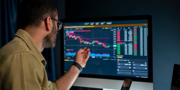 Man analyzing financial data on a computer screen.